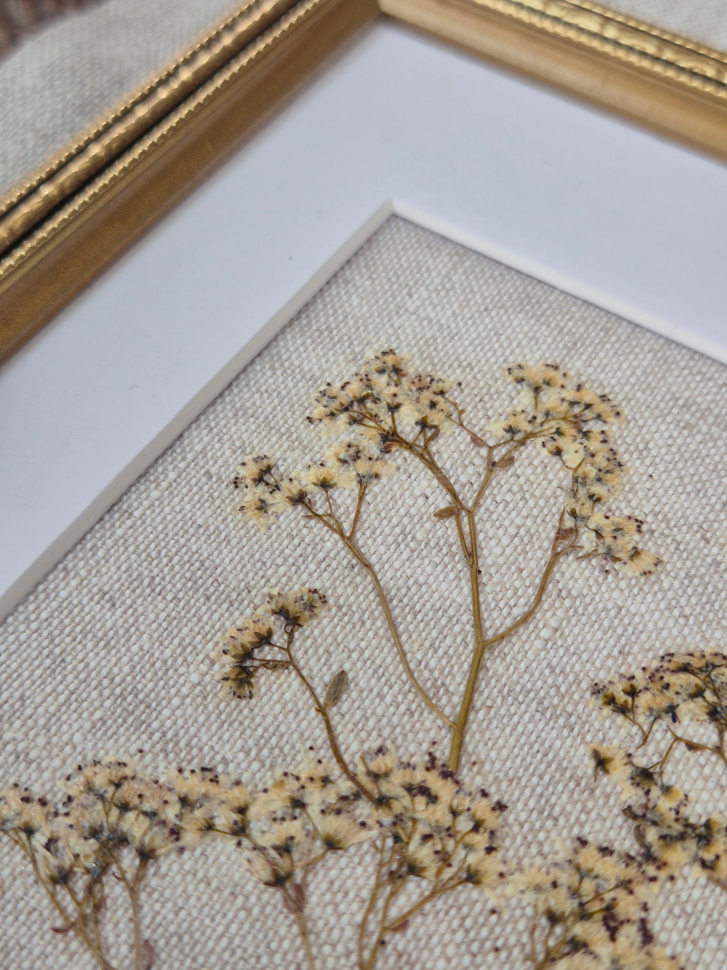 dried pressed flower art on linen