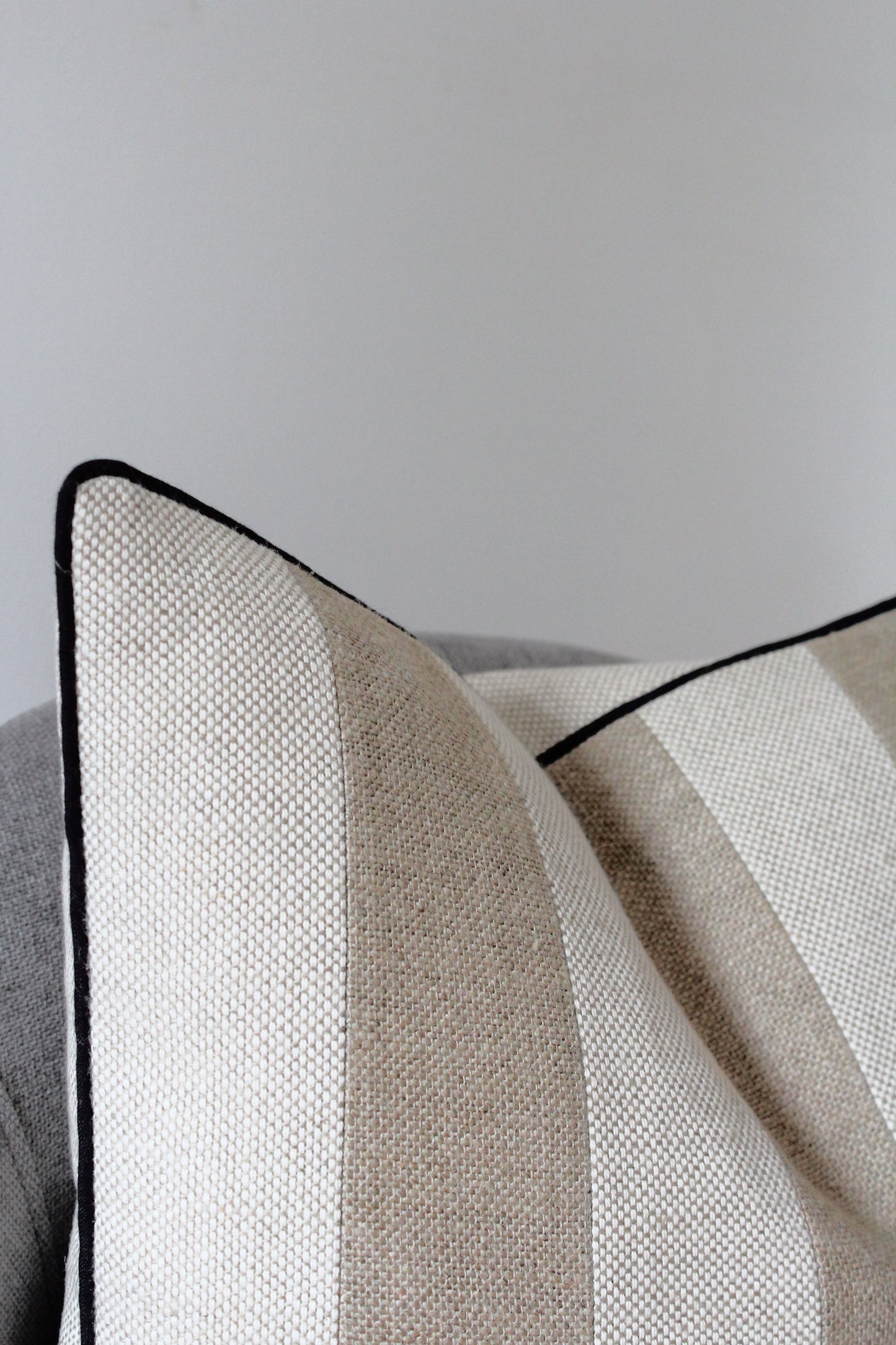 Classic neutral striped linen cushion cover with black piping edge