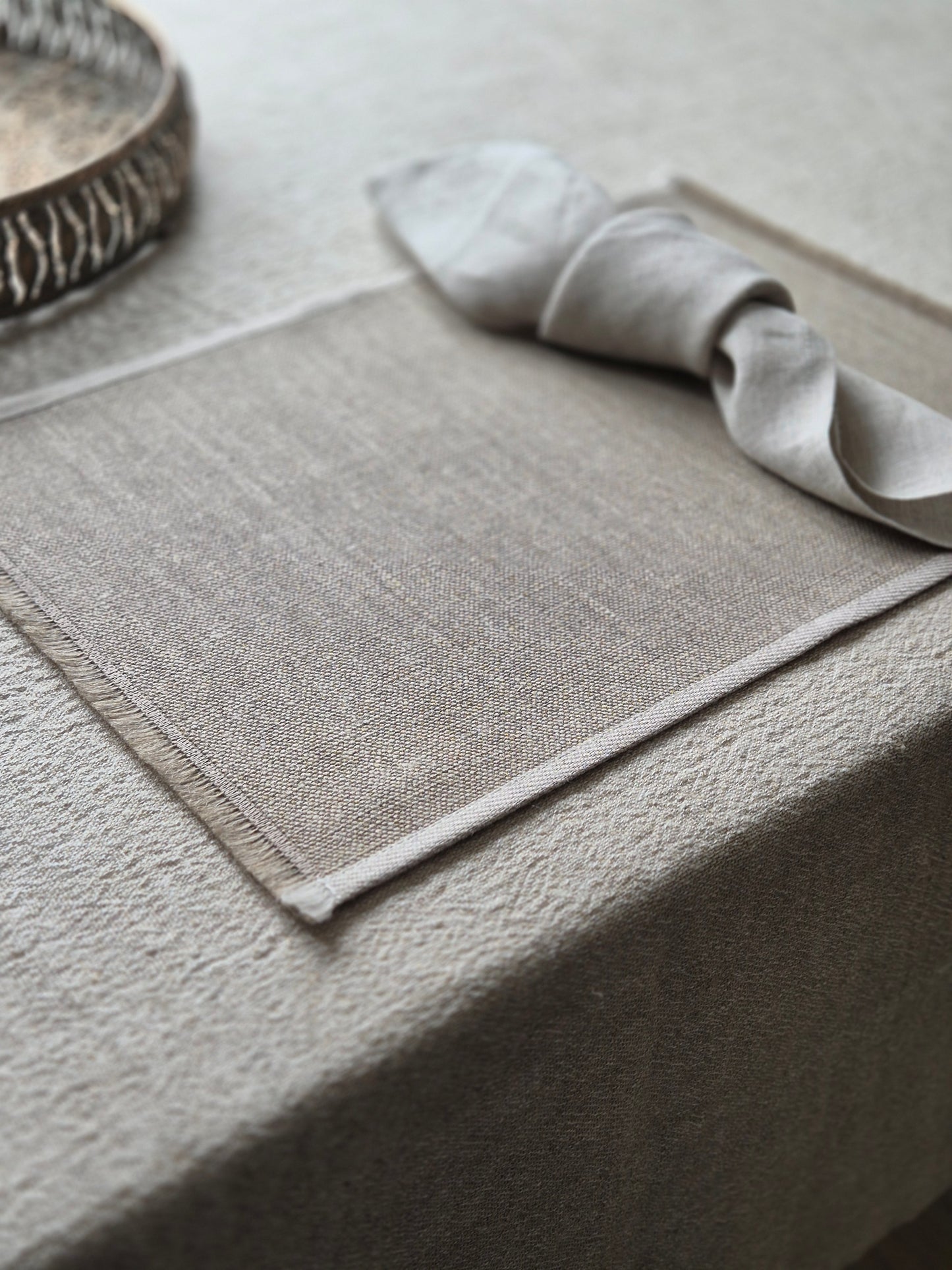 Natural stone linen placemat with hand brushed edges and contrasting oatmeal trim