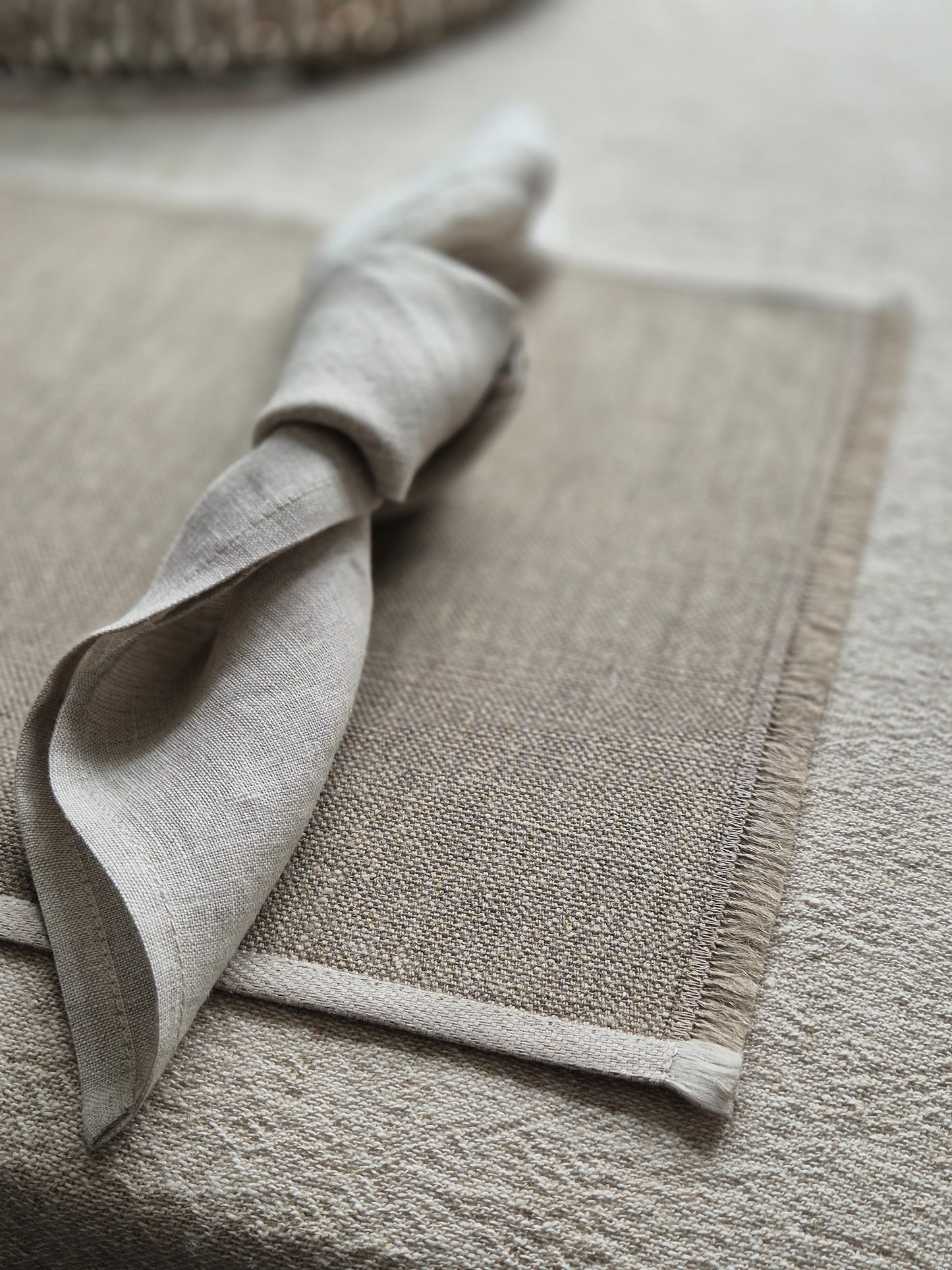 Natural stone linen placemat with hand brushed edges and contrasting oatmeal trim