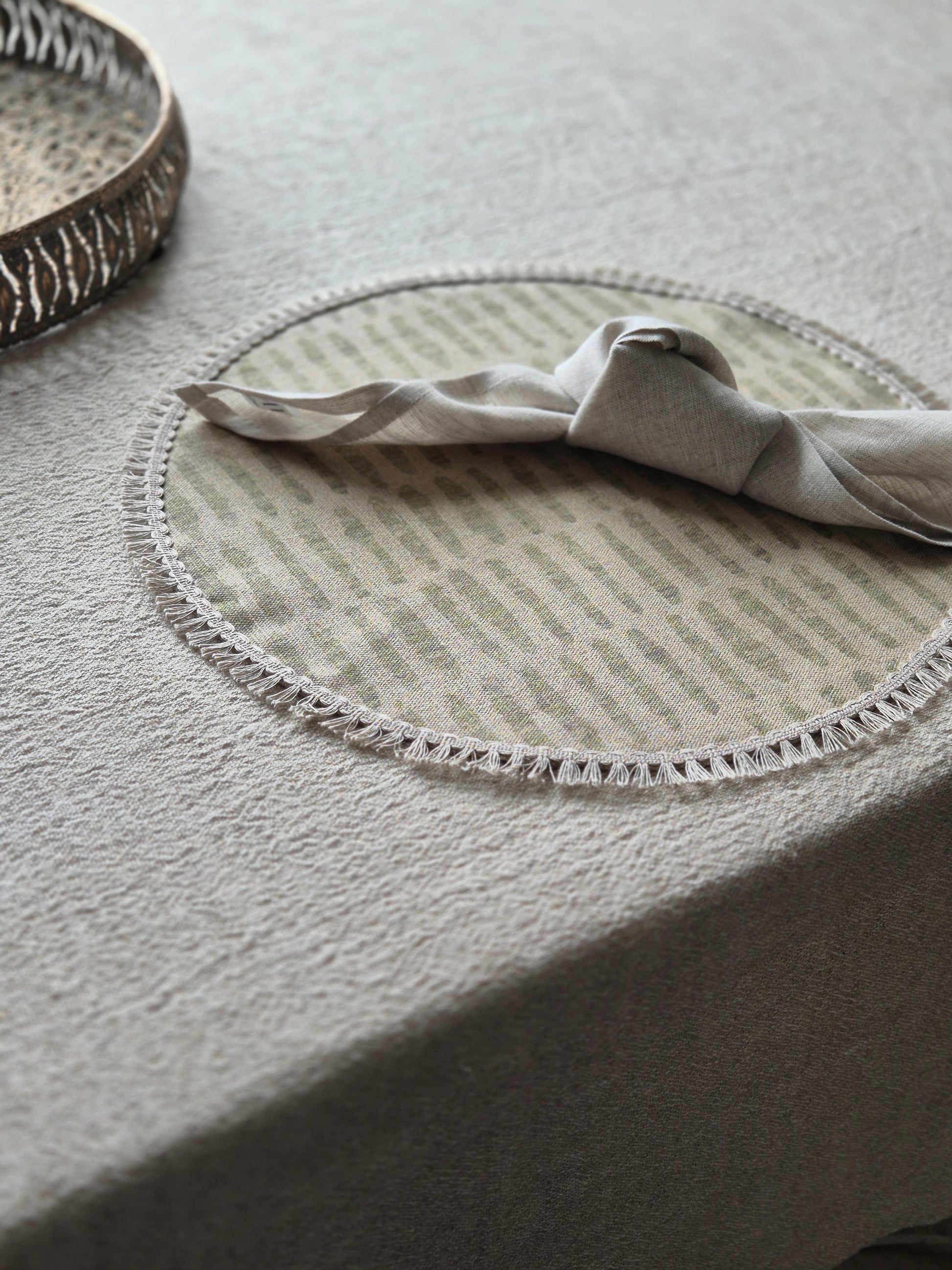 Mia round linen placemat in naturals tone and soft sage green colour with linen fringe trim