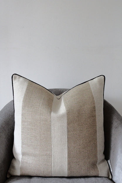 Pure flax linen cushion cover in classic rustic heavy weight linen in oatmeal beige and sand colour. Contrasting two stripe design with modern black piping edge
